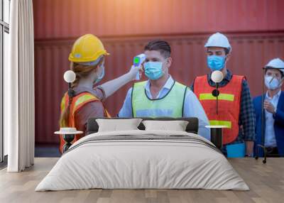 Woman worker used a medical Digital  temperature Thermometer to check staff body temperature before start work in factory ,they wearing face mask the concept of a corona virus [Covid-19] screening. Wall mural